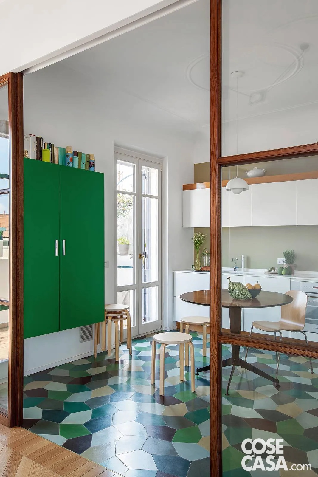 Unico pezzo d’epoca, il piccolo tavolo da caffè anni ’60 per il pranzo – con piano tondo dello stesso diametro della cornice a stucco sul soffitto – si modernizza con i grintosi accenti verdi del maxi mosaico di piastrelle e della madia. Foto di Cristina Galliena Bohman. Unico pezzo d’epoca, il piccolo tavolo da caffè anni ’60 per il pranzo – con piano tondo dello stesso diametro della cornice a stucco sul soffitto – si modernizza con i grintosi accenti verdi del maxi mosaico di piastrelle e della madia. Foto di Cristina Galliena Bohman.