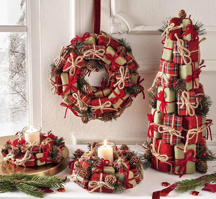 È composto da tanti piccoli pacchi regalo, rivestiti in tessuto colorato e chiusi da cordini, l'alberello di Natale, decorato da rametti di pino e pigne. Misura Ø 18 x H 46 cm. Prezzo 42 euro. È  disponibile anche la corona coordinata da appendere sulla parete per dare vita ad un angolo “speciale”, misura Ø 26 cm, prezzo 39,90 euro. I portacandele che possono essere usati anche come centrotavola sono disponibili in due formati. Misurano Ø  15 cm e Ø 22 cm. prezzo a partire da 17 euro. Tutto di Brandani. www.brandani.it È composto da tanti piccoli pacchi regalo, rivestiti in tessuto colorato e chiusi da cordini, l'alberello di Natale, decorato da rametti di pino e pigne. Misura Ø 18 x H 46 cm. Prezzo 42 euro. È  disponibile anche la corona coordinata da appendere sulla parete per dare vita ad un angolo “speciale”, misura Ø 26 cm, prezzo 39,90 euro. I portacandele che possono essere usati anche come centrotavola sono disponibili in due formati. Misurano Ø  15 cm e Ø 22 cm. prezzo a partire da 17 euro. Tutto di Brandani. www.brandani.it