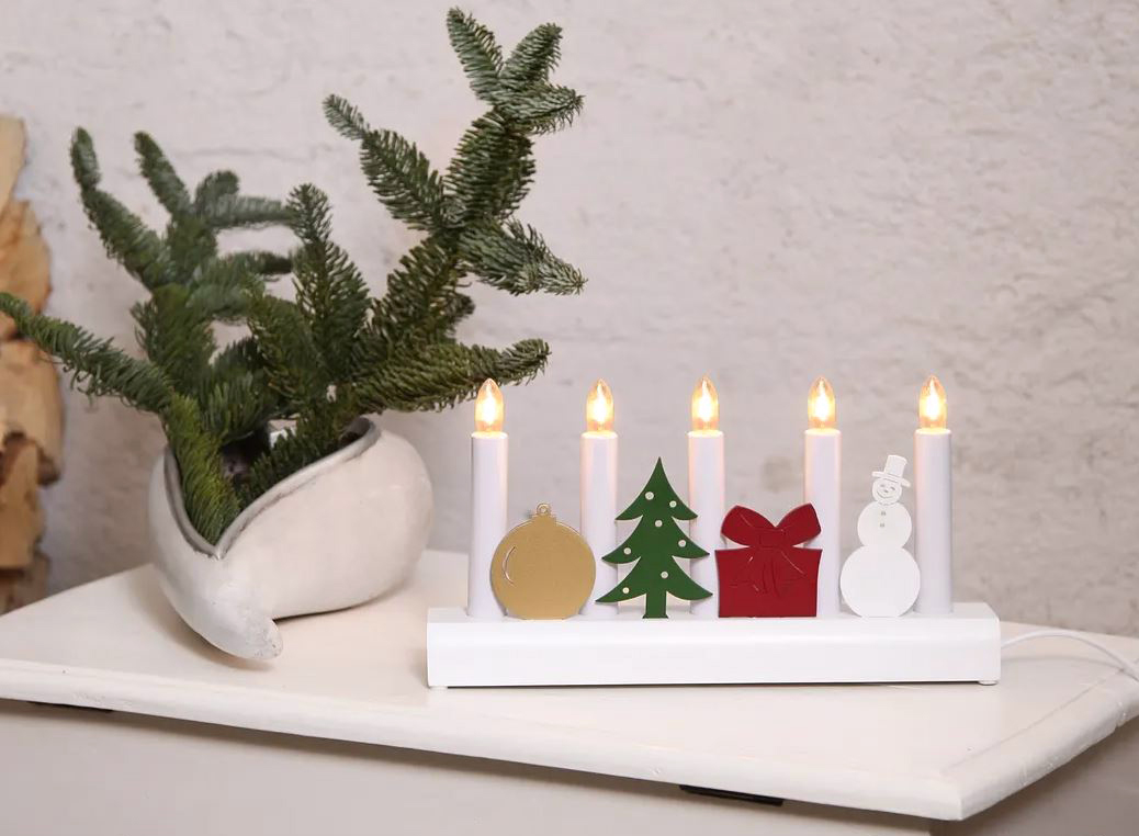 La decorazione luminosa Julia di Star Trading in vendita su bonami è dotata di cinque lampadine a forma di candide candele intervallate da quattro simboli stilizzati del Natale: una pallina dorata, un abete verde, un pacchetto rosso e un pupazzo di neve bianco. È realizzata in legno e plastica. Misura L 28 x P 6 x H 15 cm. Prezzo 30,40 euro. www.bonami.it La decorazione luminosa Julia di Star Trading in vendita su bonami è dotata di cinque lampadine a forma di candide candele intervallate da quattro simboli stilizzati del Natale: una pallina dorata, un abete verde, un pacchetto rosso e un pupazzo di neve bianco. È realizzata in legno e plastica. Misura L 28 x P 6 x H 15 cm. Prezzo 30,40 euro. www.bonami.it