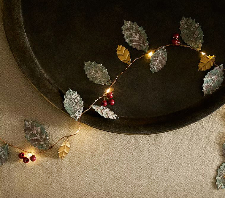 La ghirlanda decorativa in metallo di Zara Home è caratterizzata da rami e foglie di agrifoglio illuminate da piccole luci, alimentate a batteria, che fanno capolino tra le bacche rosse. Può essere appesa o posizionata sulla tavola di Natale. Misura L 200 x P 5 x H 5 cm. Prezzo 39,99 euro. www.zarahome.com La ghirlanda decorativa in metallo di Zara Home è caratterizzata da rami e foglie di agrifoglio illuminate da piccole luci, alimentate a batteria, che fanno capolino tra le bacche rosse. Può essere appesa o posizionata sulla tavola di Natale. Misura L 200 x P 5 x H 5 cm. Prezzo 39,99 euro. www.zarahome.com