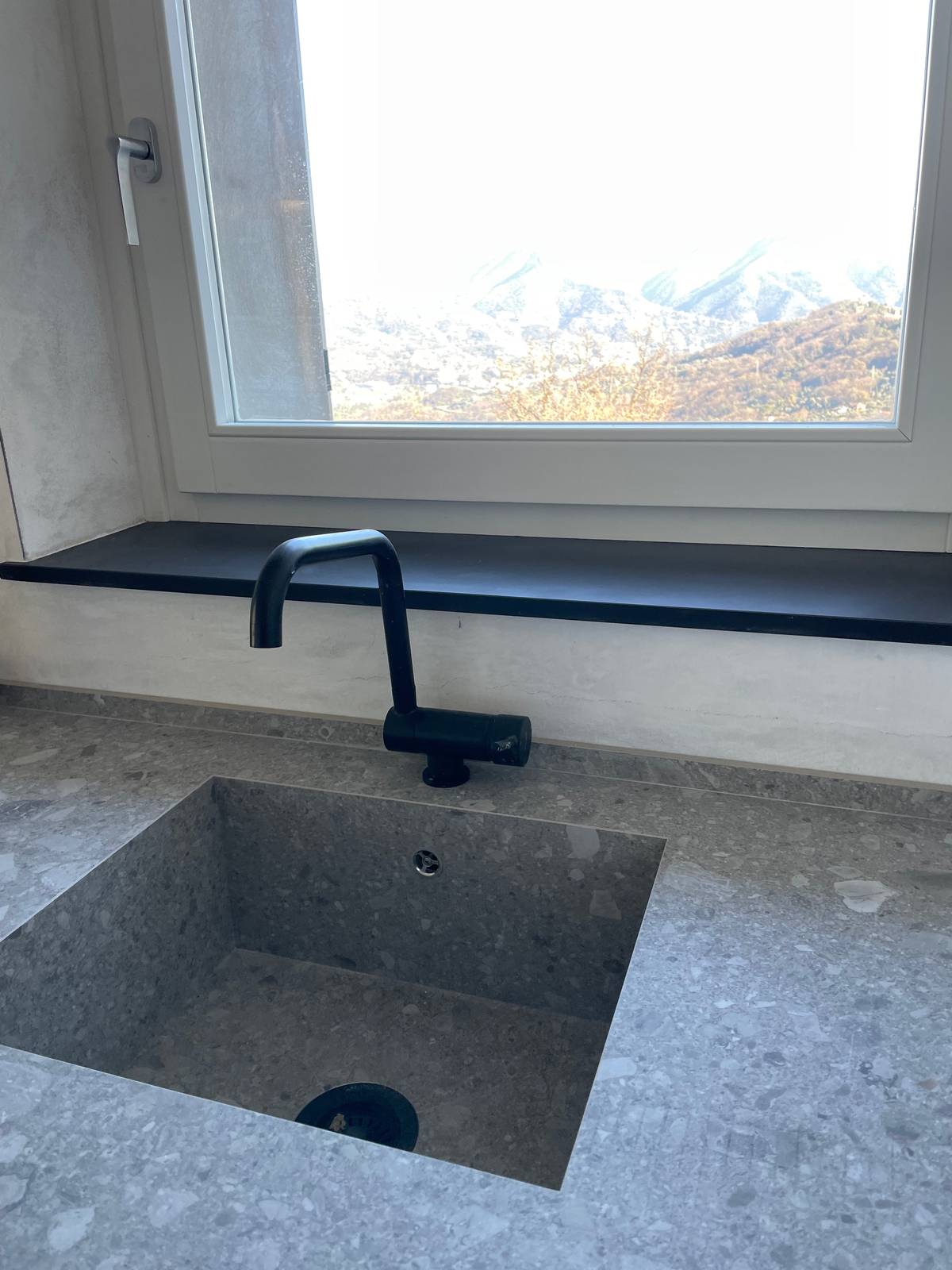 Per creare una soluzione continua nella cucina in muratura, il lavandino è stato integrato nel piano. Ed è stato poi abbinato a una rubinetteria minimal di colore nero Per creare una soluzione continua nella cucina in muratura, il lavandino è stato integrato nel piano. Ed è stato poi abbinato a una rubinetteria minimal di colore nero