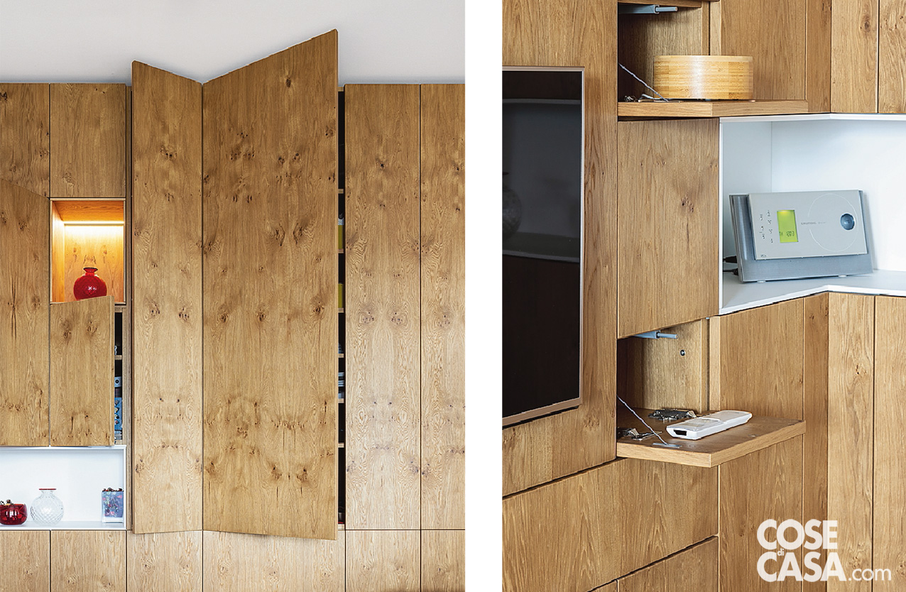 Parete attrezzata in legno che nel soggiorno nasconde vani per le stoviglie Parete attrezzata in legno che nel soggiorno nasconde vani per le stoviglie