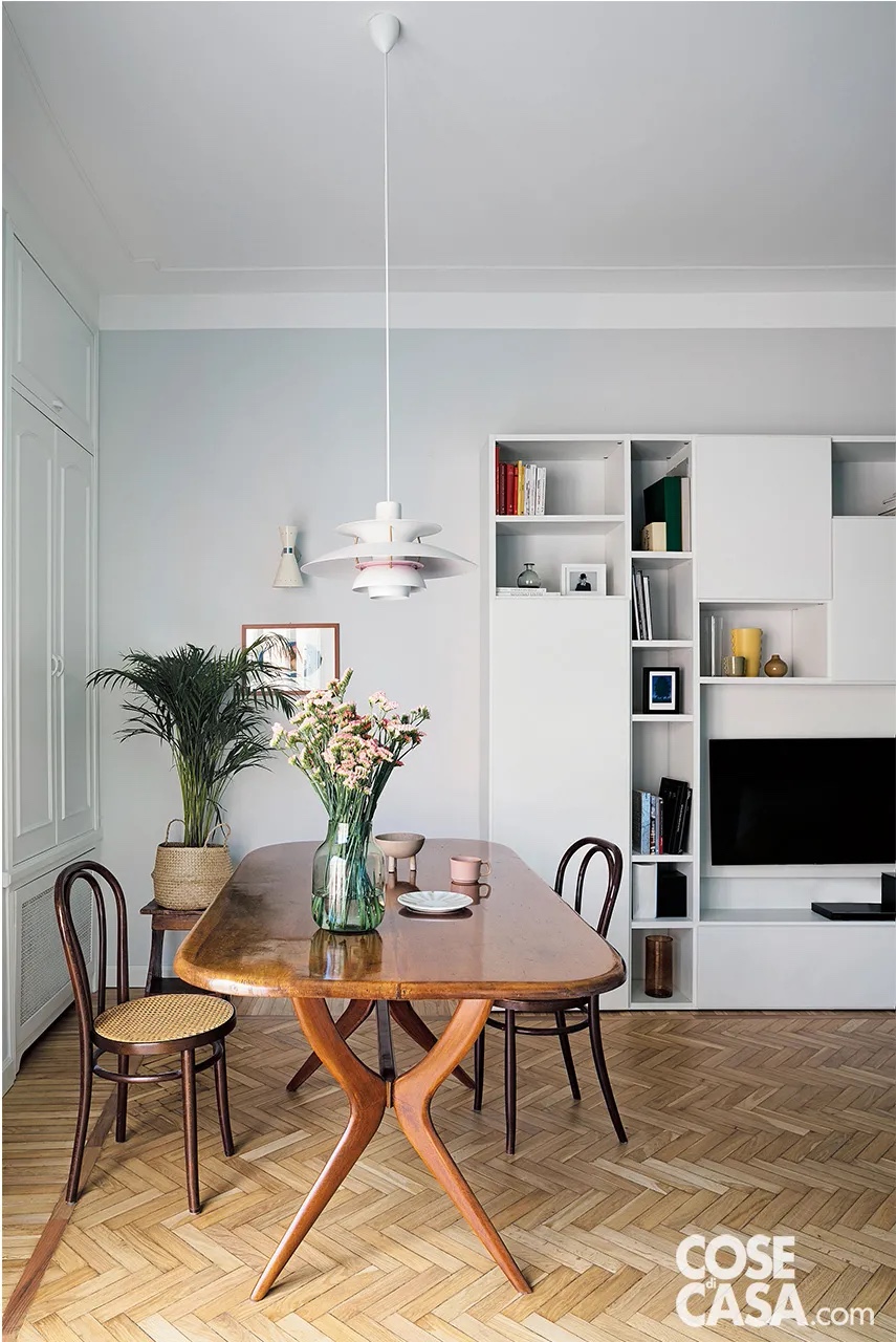 Nella zona pranzo del living, la libreria a giorno in laccato bianco è stata riadattata dalla precedente abitazione. Il tavolo in legno con bordi stondati e le sedie Thonet in paglia di Vienna sono di modernariato. Il piano è illuminato dalla sospensione PH5 di Louis Poulsen. L’applique bianca a doppio cono è di GB Tansini. L’acquerello incorniciato è opera della proprietaria. Nella zona pranzo del living, la libreria a giorno in laccato bianco è stata riadattata dalla precedente abitazione. Il tavolo in legno con bordi stondati e le sedie Thonet in paglia di Vienna sono di modernariato. Il piano è illuminato dalla sospensione PH5 di Louis Poulsen. L’applique bianca a doppio cono è di GB Tansini. L’acquerello incorniciato è opera della proprietaria.