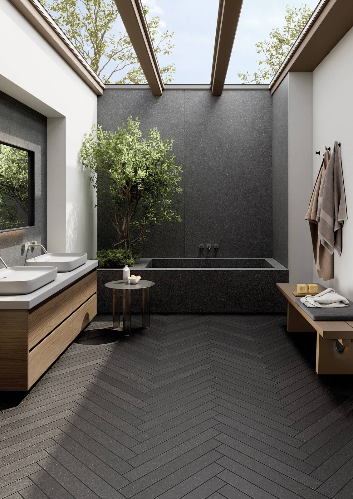 Nell’immagine sofisticato ambiente bagno realizzato con Lavica, la collezione di Ceramiche Keope che cattura l’essenza della pietra vulcanica siciliana. La finitura impiegata è Anthracite: a parete nel grande formato 120x278, a pavimento nel formato 7,5x60 con posa a spina di pesce. Vasca rivestita con le grandi lastre 120x278 della medesima finitura.