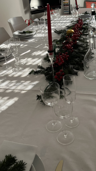 Tavola di Capodanno con centrotavola con rami di abete