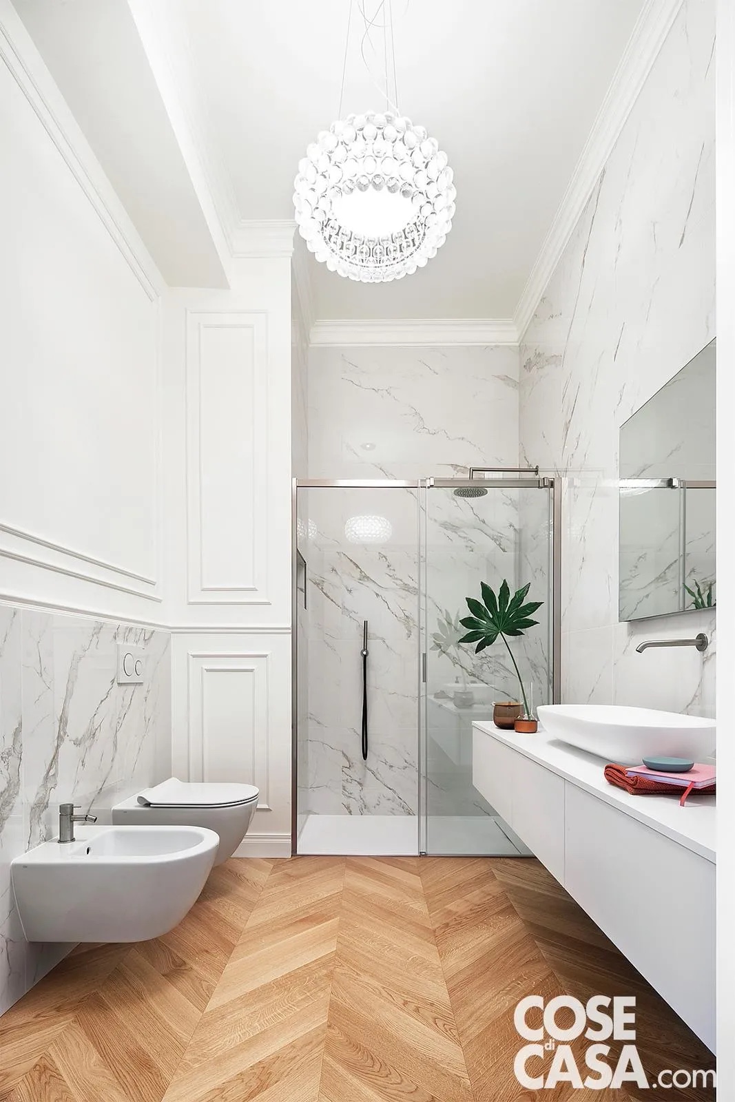 Bagno cieco con parquet in rovere posato a spina di pesce e pareti con profili decorativi nella parte superiore e lastre in gres effetto marmo in quella inferiore. Progetto: Studio Tenca Associati. Foto: Riccardo Gasperoni. Styling: Irene Baratto. Bagno cieco con parquet in rovere posato a spina di pesce e pareti con profili decorativi nella parte superiore e lastre in gres effetto marmo in quella inferiore. Progetto: Studio Tenca Associati. Foto: Riccardo Gasperoni. Styling: Irene Baratto.