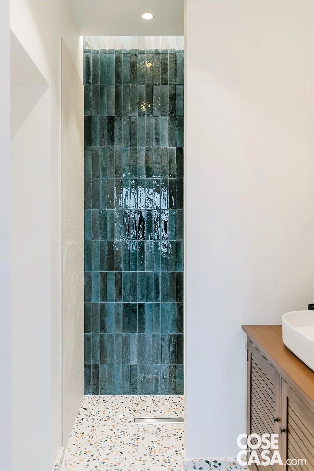 L’antibagno è arredato con un mobile in legno completo di ante e il lavabo ovale da appoggio. La doccia in muratura a filo pavimento (lo scarico con piletta rettangolare in acciaio inox è inserito nelle piastrelle del pavimento) è l'elemento più caratterizzante della stanza da bagno con il rivestimento a terra che prosegue nell'antibagno (in agglomerato a base marmo, coll. SM Marble-900 di Santamargherita, santamargherita.net). Le pareti interne del box sono rivestite in piastrelline di gres porcellanato blu mare, posate in verticale rettangolari (6 X 24 cm, coll. Crogiolo Lume di Marazzi) e l’intero vano doccia walk-in è stato valorizzato da un “pozzo di luce” nel soffitto molto suggestivo. Foto: Paolo Properzi. Progetto: Arch. Claudio Fava. L’antibagno è arredato con un mobile in legno completo di ante e il lavabo ovale da appoggio. La doccia in muratura a filo pavimento (lo scarico con piletta rettangolare in acciaio inox è inserito nelle piastrelle del pavimento) è l'elemento più caratterizzante della stanza da bagno con il rivestimento a terra che prosegue nell'antibagno (in agglomerato a base marmo, coll. SM Marble-900 di Santamargherita, santamargherita.net). Le pareti interne del box sono rivestite in piastrelline di gres porcellanato blu mare, posate in verticale rettangolari (6 X 24 cm, coll. Crogiolo Lume di Marazzi) e l’intero vano doccia walk-in è stato valorizzato da un “pozzo di luce” nel soffitto molto suggestivo. Foto: Paolo Properzi. Progetto: Arch. Claudio Fava.