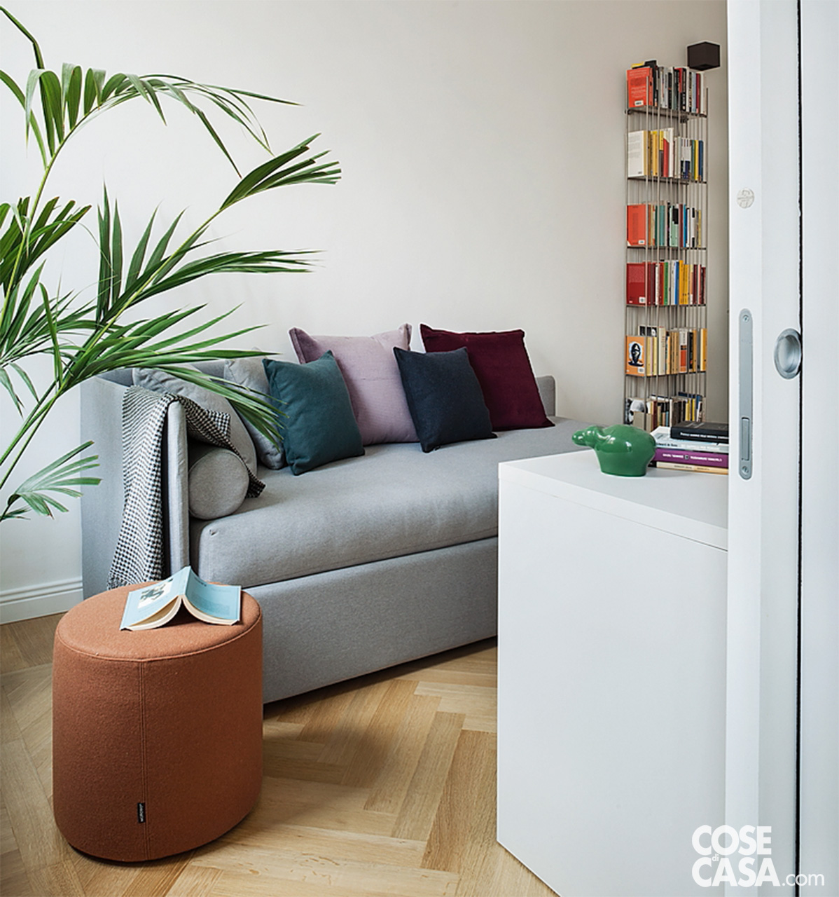 Studio con divano grigio trasformabile in letto