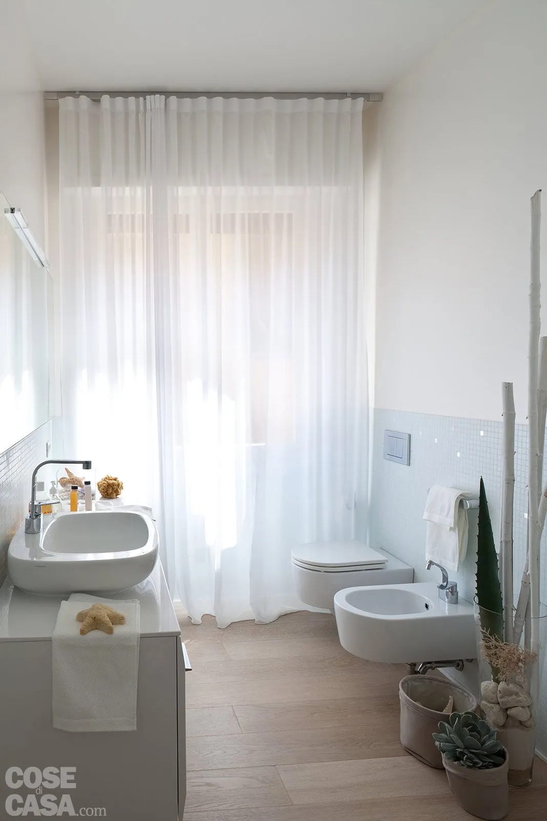 Nel bagno con parquet in rovere sbiancato, attrezzato su due lati, la fascia bassa delle pareti è rivestita fino a un’altezza di 120 cm circa con un mosaico monocromatico colore azzurro acqua. Progetto: arch. Rosy Rozza. Foto: Cristina Fiorentini. Nel bagno con parquet in rovere sbiancato, attrezzato su due lati, la fascia bassa delle pareti è rivestita fino a un’altezza di 120 cm circa con un mosaico monocromatico colore azzurro acqua. Progetto: arch. Rosy Rozza. Foto: Cristina Fiorentini.