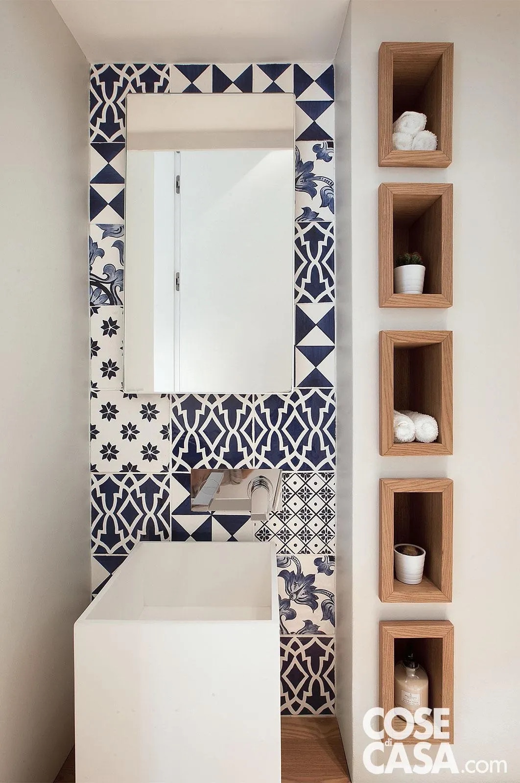 Bagno piccolo con parquet e maioliche bianche e blu di gusto contemporaneo, lavabo in Corian® e pareti rivestite in resina bianca.  Progetto casa: interior designer Ernesto Fusco. Foto: Roberto Pierucci. Bagno piccolo con parquet e maioliche bianche e blu di gusto contemporaneo, lavabo in Corian® e pareti rivestite in resina bianca.  Progetto casa: interior designer Ernesto Fusco. Foto: Roberto Pierucci.