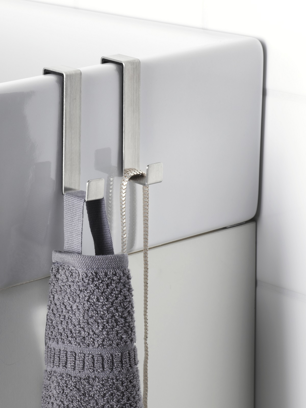 I ganci portasciugamani inox LILLÅNGEN di Ikea hanno forme lineari. Ciascuno misura L 1,5 x H 8,3 cm. Prezzo della coppia 4,95 euro. www.ikea.com