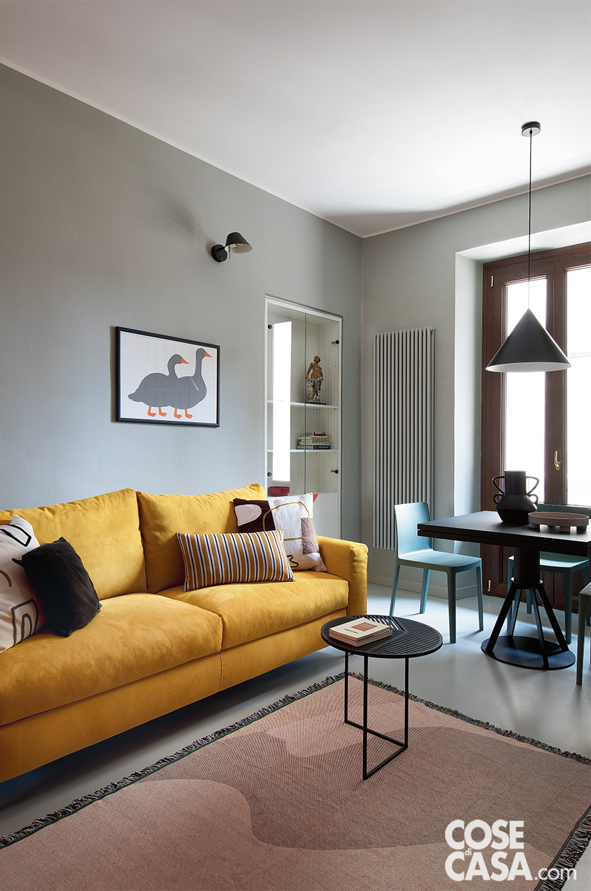 soggiorno con parete grigia e divano gialo