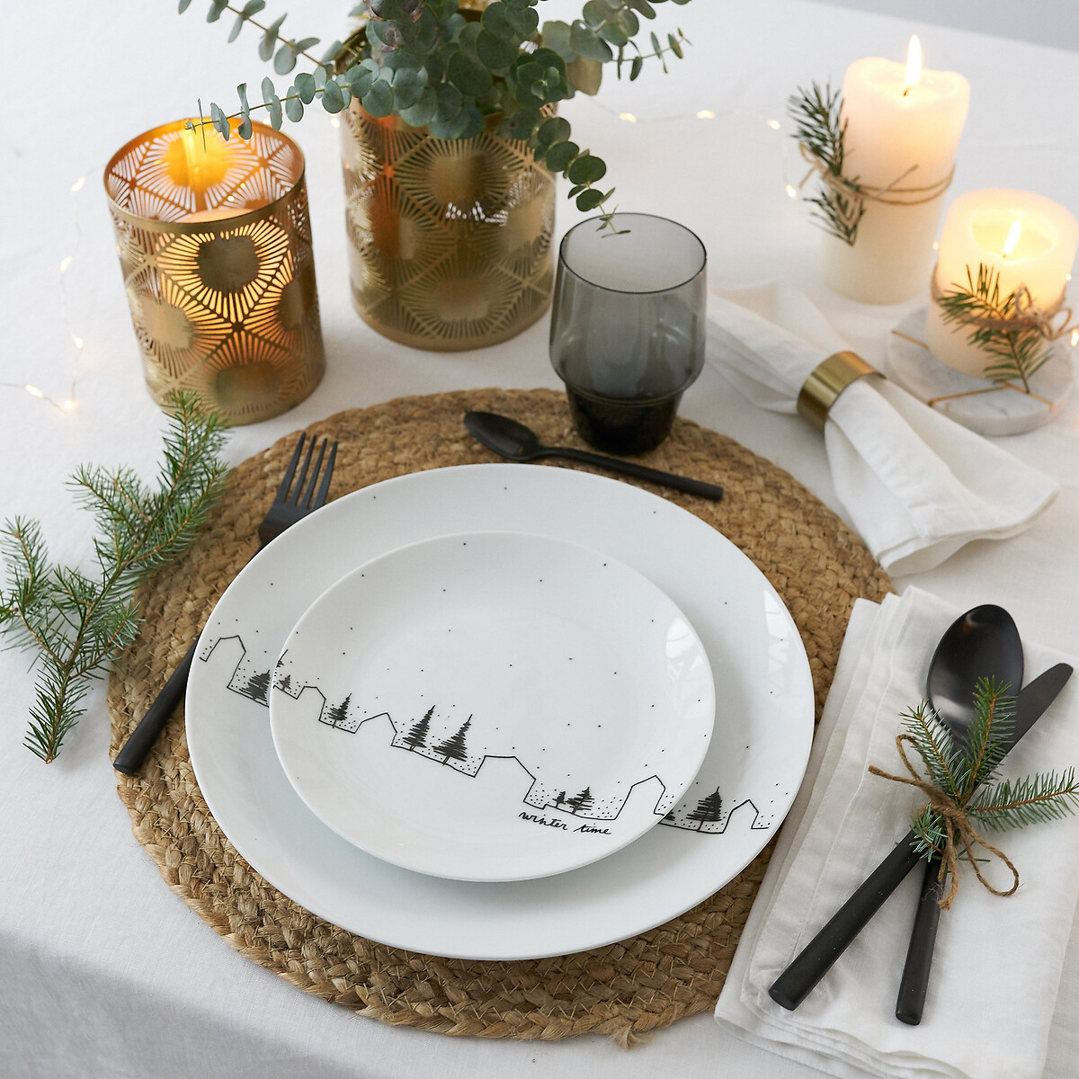 Un paesaggio stilizzato nero decora i piatti Miwin di La Redoute Interieurs che danno vita ad un'apparecchiatura minimale e raffinata; sono realizzati in porcellana bianca. Il piatto piano misura Ø 26,7 cm, prezzo 29,99 euro (per il set da 4 pezzi). Sono posizionati su una tovaglietta rotonda in fibra naturale che funge da posto tavola sulla tovaglia candida. Le posate Cierna sono realizzate in acciaio inossidabile 18/8 nella finitura nero carbone aspetto opaco, prezzo 69,99 euro (per il set da 16 pezzi). Candele e lanterne completano la mise en place natalizia. www.laredoute.it Un paesaggio stilizzato nero decora i piatti Miwin di La Redoute Interieurs che danno vita ad un'apparecchiatura minimale e raffinata; sono realizzati in porcellana bianca. Il piatto piano misura Ø 26,7 cm, prezzo 29,99 euro (per il set da 4 pezzi). Sono posizionati su una tovaglietta rotonda in fibra naturale che funge da posto tavola sulla tovaglia candida. Le posate Cierna sono realizzate in acciaio inossidabile 18/8 nella finitura nero carbone aspetto opaco, prezzo 69,99 euro (per il set da 16 pezzi). Candele e lanterne completano la mise en place natalizia. www.laredoute.it