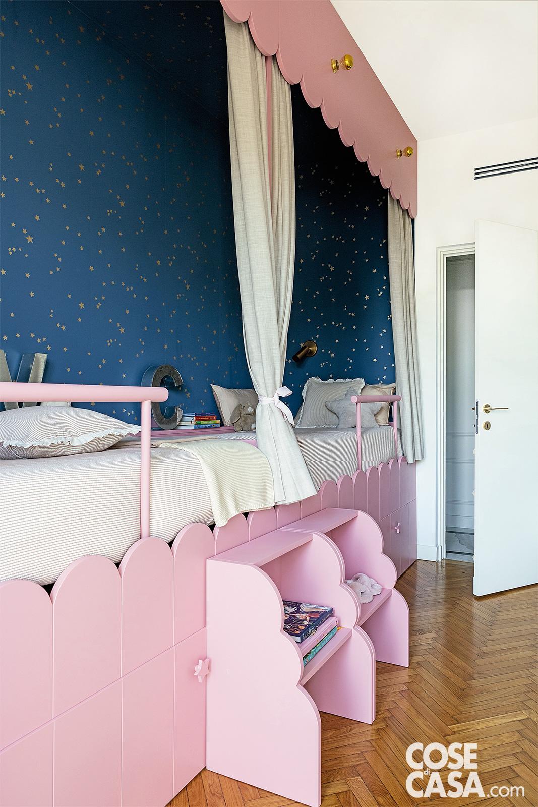 La soluzione in questa cameretta in stile romantico, con letto scenografico salvaspazio dotato di cassettoni, è la carta da parati che raffigura un cielo notturno stellato, che contrasta con gli elementi rosa baby della stanza. Foto: Cristina Galliena Bohman. Styling: Rosaria Sofia Galli. Progetto: Studio Laboratorio83, arch. Alessandra Nicotra, arch. Michele Pietrogrande. La soluzione in questa cameretta in stile romantico, con letto scenografico salvaspazio dotato di cassettoni, è la carta da parati che raffigura un cielo notturno stellato, che contrasta con gli elementi rosa baby della stanza. Foto: Cristina Galliena Bohman. Styling: Rosaria Sofia Galli. Progetto: Studio Laboratorio83, arch. Alessandra Nicotra, arch. Michele Pietrogrande.