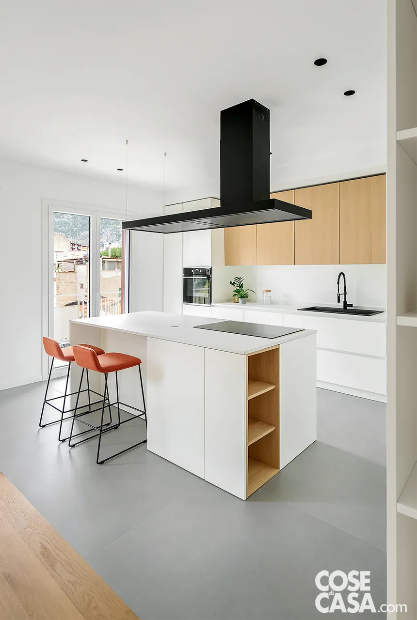 Cucina bianca con isola e vani a giorno in legno