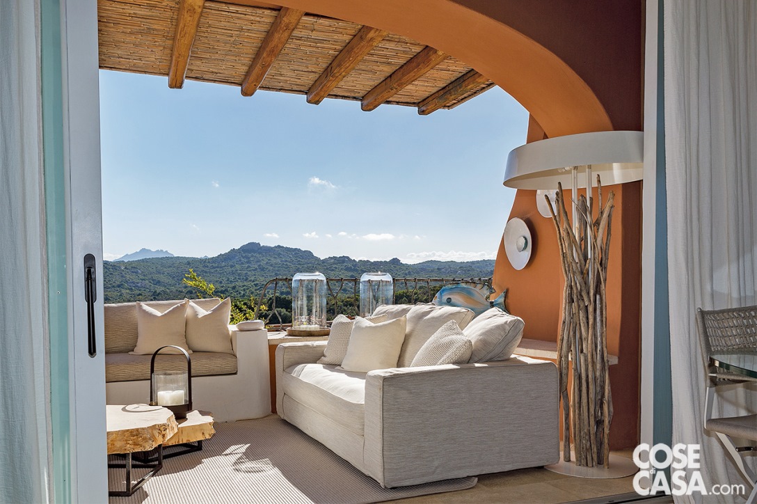 Anche l’esterno può essere arredato con l’illuminazione per creare un’atmosfera speciale. Per questo terrazzino pensato come area di conversazione con divani posti ad angolo è stata aggiunta una lampada da terra con rami in legno di Blue Nature, che contribuisce a esaltare lo stile naturale di tutta dell'abitazione – Foto: Rossella Murgia. Progetto d’interior: Berenice Vien dal Mare.