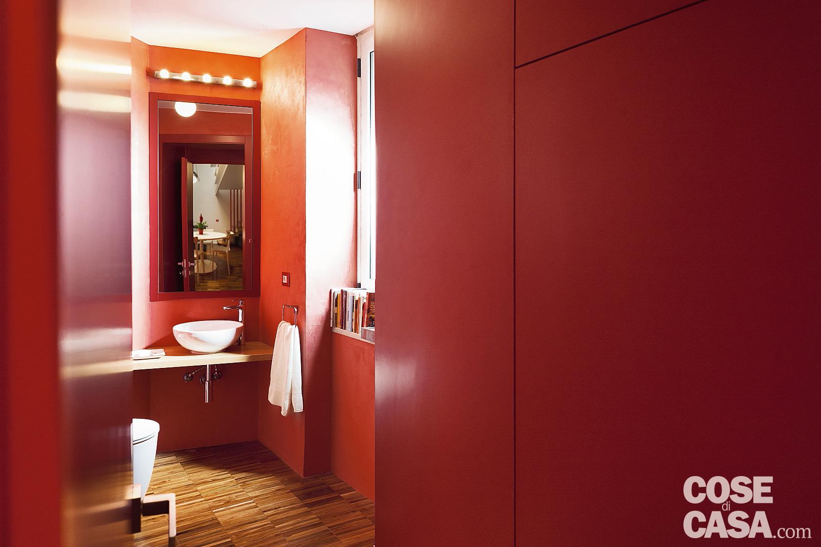 In un monolocale in cui si gioca col colore rosso, riprenderlo anche nel bagno serve a dare continuità ampliando la prospettiva  – Foto: Gaetano Del Mauro. Progetto: Studio 74ram, architetti Emilia Abate, Francesco Rotondale.