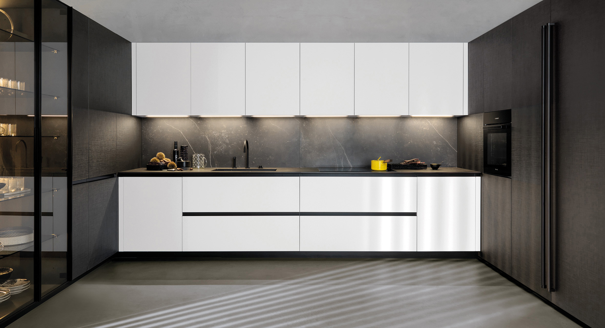 Grandi dimensioni per la cucina a golfo Telero di Euromobil che si articola in una zona attrezzata centrale e in due laterali con armadiature. Le ante lisce, delle basi e dei pensili, sono nella finitura vetro bianco ottico. Il top con il lavello coordinato è realizzato in Dekton Kelya effetto marmo scuro che dà vita ad un raffinato contrasto. Un modulo base da 60 cm, prezzo a partire da 412 euro + Iva. www.euromobil.com Grandi dimensioni per la cucina a golfo Telero di Euromobil che si articola in una zona attrezzata centrale e in due laterali con armadiature. Le ante lisce, delle basi e dei pensili, sono nella finitura vetro bianco ottico. Il top con il lavello coordinato è realizzato in Dekton Kelya effetto marmo scuro che dà vita ad un raffinato contrasto. Un modulo base da 60 cm, prezzo a partire da 412 euro + Iva. www.euromobil.com