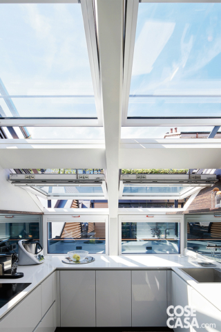 Cucina a U bianca inondata di luce grazie alla moltitudine di finestre Cucina a U bianca inondata di luce grazie alla moltitudine di finestre