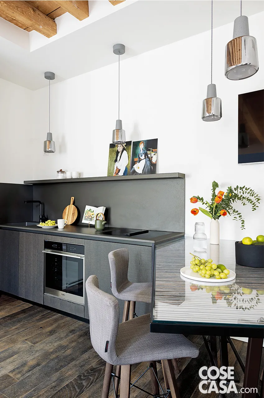 L’elegante cucina moderna senza pensili con tavolo integrato ha l'alzata (come il piano) rifinita in alto da una piccola mensola su cui poggia una tela e qualche piccolo oggetto - Foto: Cristina Galliena Bohman. Styling: Laura Mauceri. Progetto: bilune studio – interior design e architettura – Silvana Tombini interior designer. L’elegante cucina moderna senza pensili con tavolo integrato ha l'alzata (come il piano) rifinita in alto da una piccola mensola su cui poggia una tela e qualche piccolo oggetto - Foto: Cristina Galliena Bohman. Styling: Laura Mauceri. Progetto: bilune studio – interior design e architettura – Silvana Tombini interior designer.