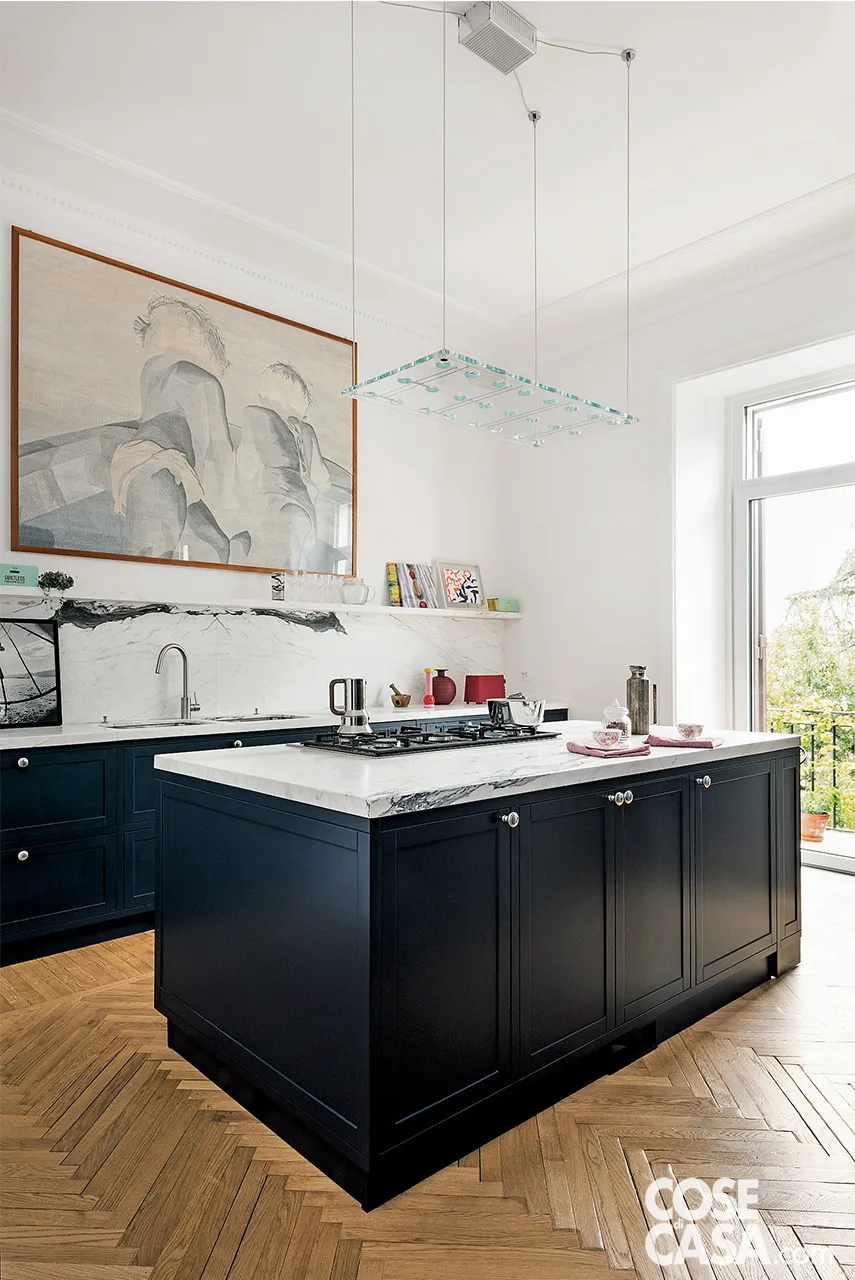 Soluzione dal design raffinato, la cucina con isola dal piano in marmo è dominata a parete da imponente quadro, posto al centro sopra una lunga mensola che corre sull'intera parete e su cui sono appoggiati piccoli oggetti - Foto: Paolo Fusco. Styling: Studio Wolo. Progetto: arch. Marco Rulli, con arch. Alessandro Fuoti, Studio 02A. Soluzione dal design raffinato, la cucina con isola dal piano in marmo è dominata a parete da imponente quadro, posto al centro sopra una lunga mensola che corre sull'intera parete e su cui sono appoggiati piccoli oggetti - Foto: Paolo Fusco. Styling: Studio Wolo. Progetto: arch. Marco Rulli, con arch. Alessandro Fuoti, Studio 02A.