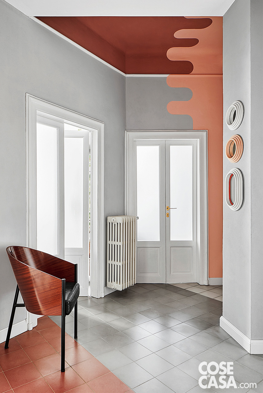 Zona d'ingresso con pareti, soffitto e pavimenti decorati nei colori bianco, grigio, rosa antico e rosso antico