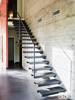 Scala con gradini a giorno in acciaio che dal piano terra conduce al livello superiore Scala con gradini a giorno in acciaio che dal piano terra conduce al livello superiore