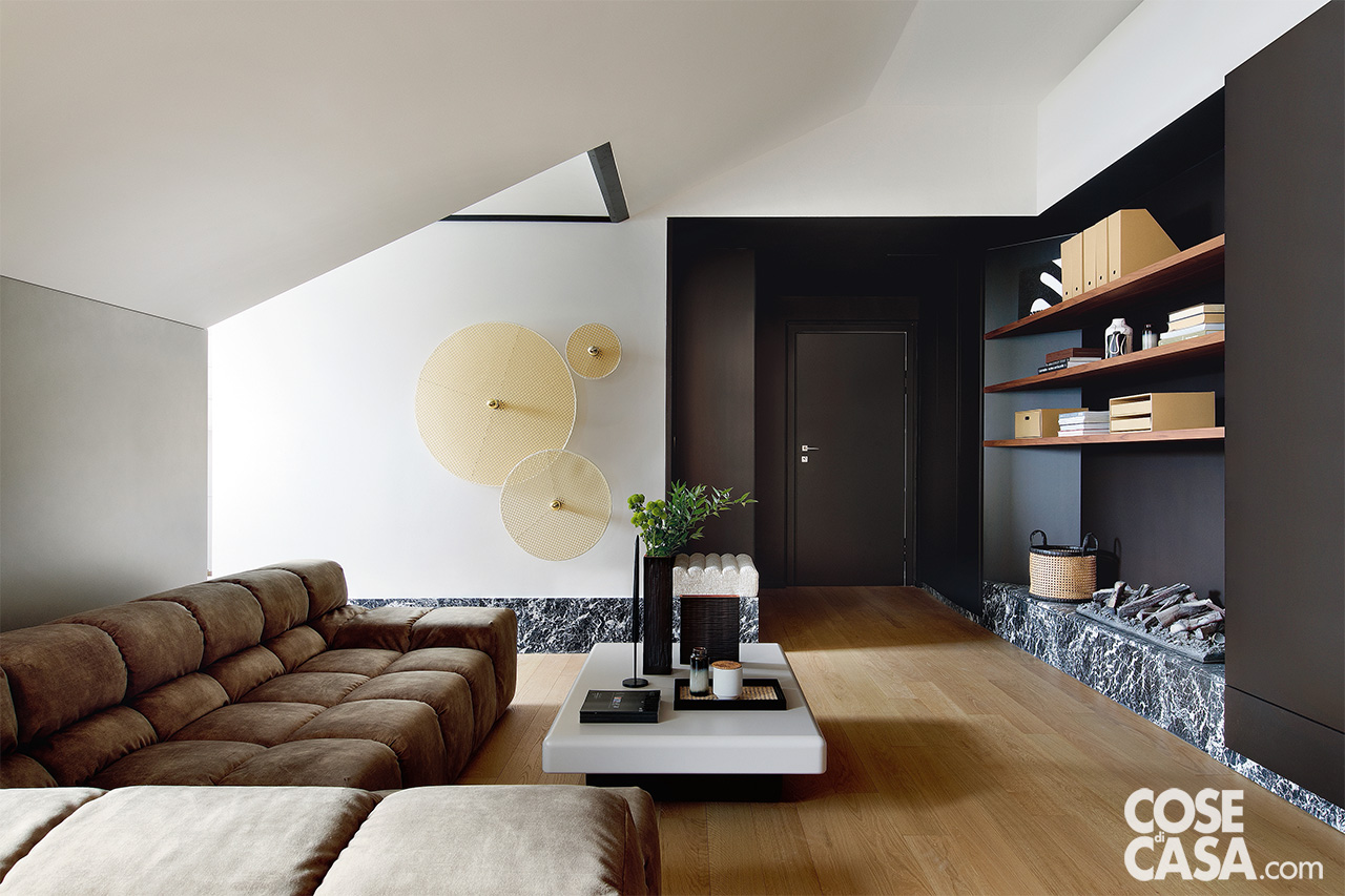 soggiorno con divano color caffe e parete con camino