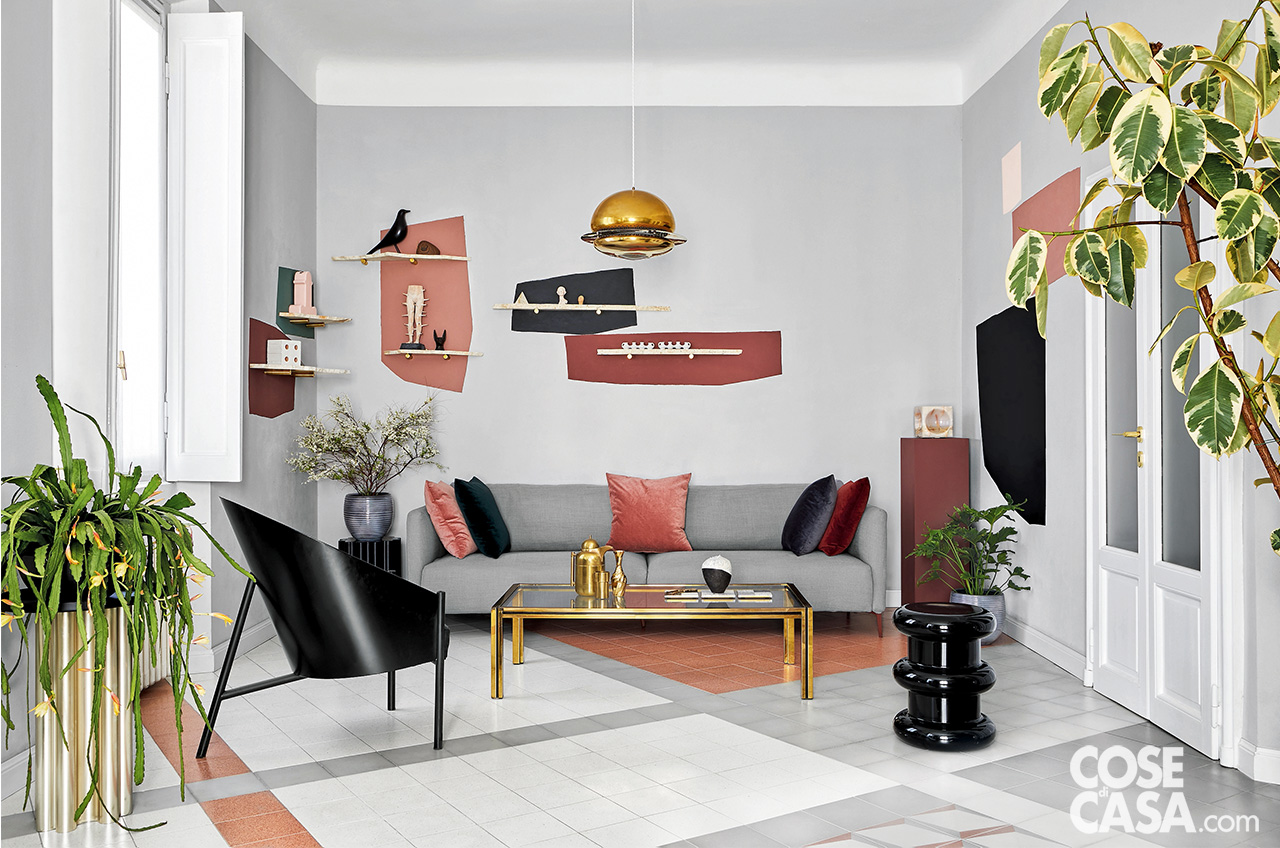 Soggiorno con divano grigio ed elementi decorativi di design alle pareti