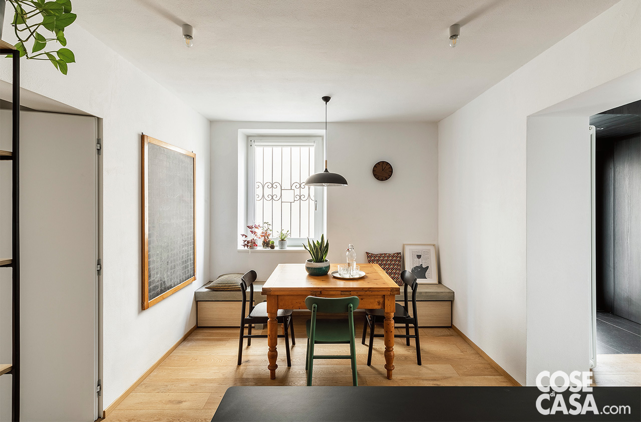 zona pranzo con tavolo in legno e sedie colorate