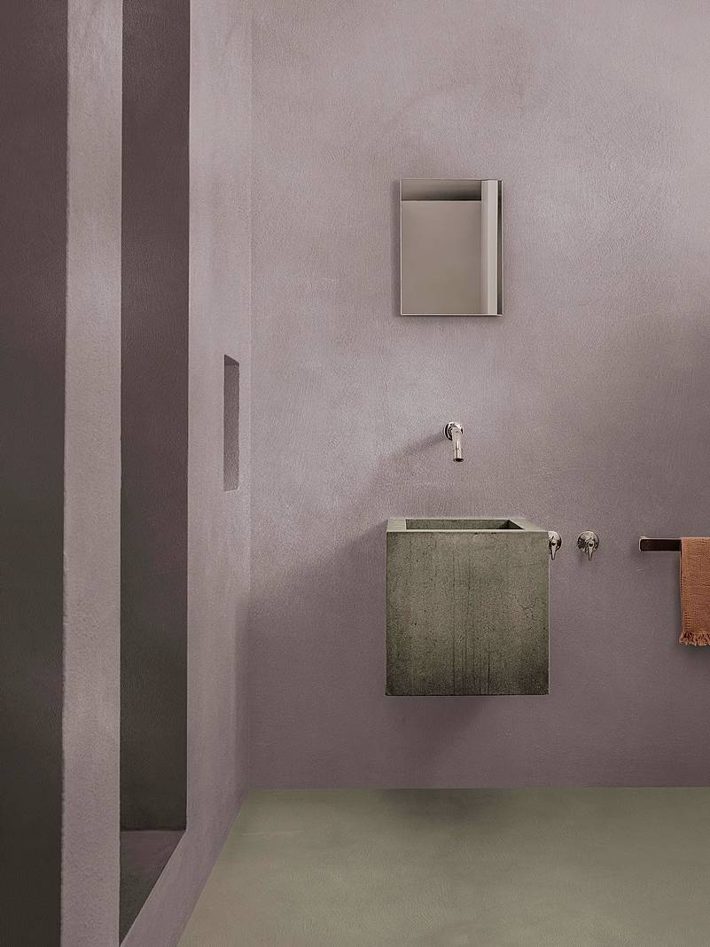 Effetto brutalista per il bagno, caratterizzato da lavabo squadrato in cemento, pavimento nello stesso materiale e pareti in grigio chiaro (pareti Cementoresina Wall Pareti bagno grigie KK 138, Pavimento Cementoresina KK 67 di Kerakoll, www.kerakoll.com. Questa scelta di materiali e colori crea un'atmosfera minimalista e moderna, tipica dello stile industriale. Per ammorbidire il risultato complessivo, potrebbero essere integrati dettagli come piante verdi e accessori in legno.Foto di Salva Lopez.