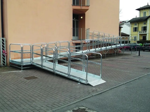 Le rampe di Ilma sono strutture prefabbricate che permettono di eliminare le barriere architettoniche, anche con le carrozzine. Sono realizzate in acciaio zincato a caldo, resistente a intemperie e condizioni climatiche difficili e si possono installare sia all'aperto che al chiuso. Il piano di camminamento è antiscivolo. Hanno larghezza di minimo di 90 cm fino a 150 cm, il parapetto è alto almeno 100 cm, la pendenza non è superiore all’8%. www.ilma-stand.com Le rampe di Ilma sono strutture prefabbricate che permettono di eliminare le barriere architettoniche, anche con le carrozzine. Sono realizzate in acciaio zincato a caldo, resistente a intemperie e condizioni climatiche difficili e si possono installare sia all'aperto che al chiuso. Il piano di camminamento è antiscivolo. Hanno larghezza di minimo di 90 cm fino a 150 cm, il parapetto è alto almeno 100 cm, la pendenza non è superiore all’8%. www.ilma-stand.com