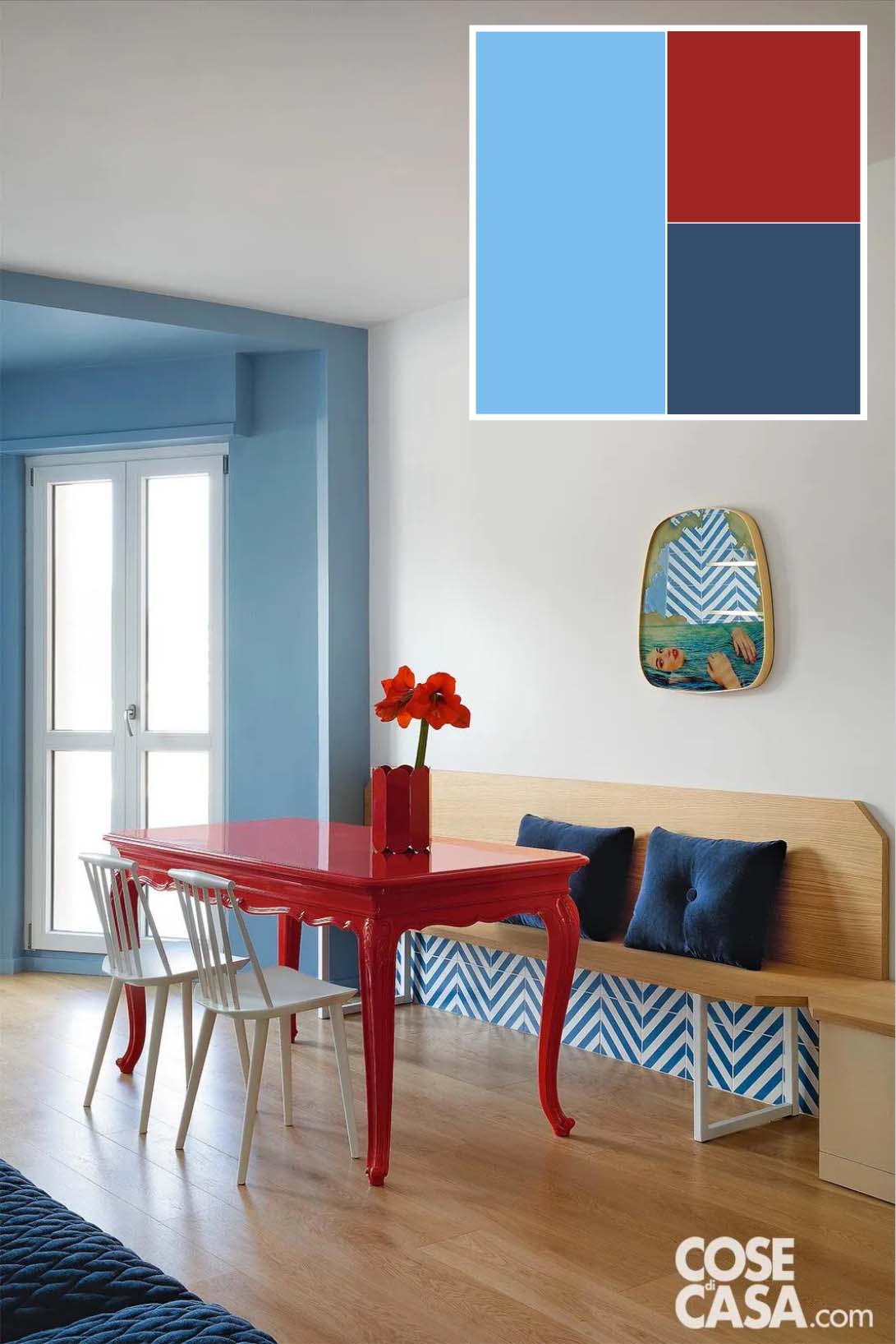 Zona pranzo parete bianca e panca in legno abbinata a un tavolo rosso. L'ambiente è aperto su quello adiacente con parete celeste. Progetto: SCEG Architetti (arch. Eirini Giannakopoulou - arch. Stefano Carera). Foto: Barbara Corsico.