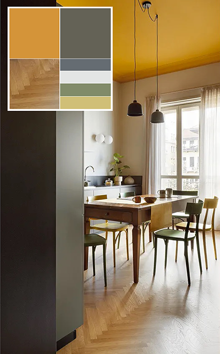 Nella cucina con basi grigie e senza pensili, il soffitto è dipinto ocra come nel soggiorno cui è collegata. Per arredi e complementi viene riproposta la medesima palette di colori del resto della casa. Le sedie sono il modello Milano 2015 di Colico. Sul tavolo - di recupero - due sospensioni Grain Pendant di Muuto, mentre l'illuminazione d'atmosfera è assicurata dalla coppia di applique Mapa di Ideal Lux. Foto: Barbara Corsico. Progetto: homarchitetti di Stefania De Paola, Roberta Massetti, Sabrina Saldo con Ottavia Giannone.