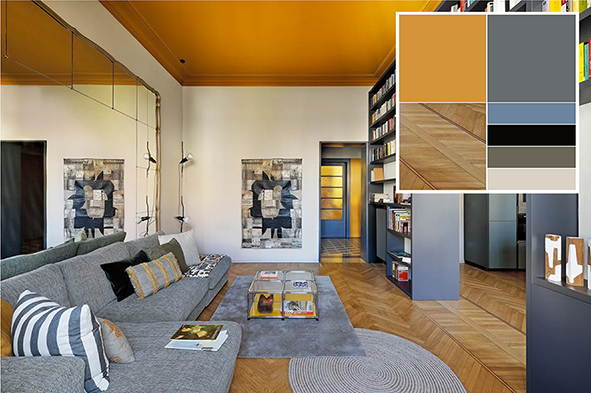 Il soggiorno, separato dalla cucina tramite la libreria bifacciale a tutta altezza, riprende i colori delle graniglie dell'ingresso: giallo ocra, scelto inusualmente per differenziare a contrasto il soffitto (tonalità E8.55.45 della serie Sikkens 501, www.sikkens.it), e grigio-azzurro per arredi nuovi su misura e serramenti interni originali. La vista dall'ingresso verso l'area pranzo evidenzia la coerenza stilistica dell'intero progetto di ristrutturazione. Il trucco di grande effetto di questa soluzione è quello di "scendere" leggermente con un bordo ocra sulle pareti. Foto: Barbara Corsico. Progetto: homarchitetti