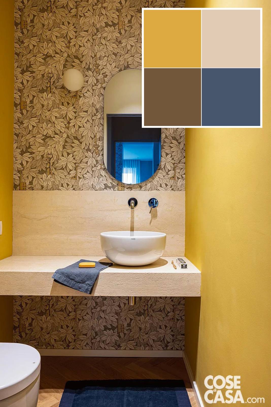 In questo bagno destinato agli ospiti e quindi più ridotto, soltanto con vaso e lavabo, le due pareti che si fronteggiano sono dipinte di giallo. La parete centrale, che ospita piano di appoggio, lavandino e specchio, è rivestita a tutta altezza con una carta da parati con disegni a foglie in tonalità beige, che viene messa in risalto dal giallo adiacente, creando un effetto di grande ricercatezza. Foto: Cristina Galliena Bohman. Styling: Laura Mauceri. Progetto: arch. Fabrizia Parlani, Torino, fabriziaparlani.com, fabrizia.parlani@hotmail.it.