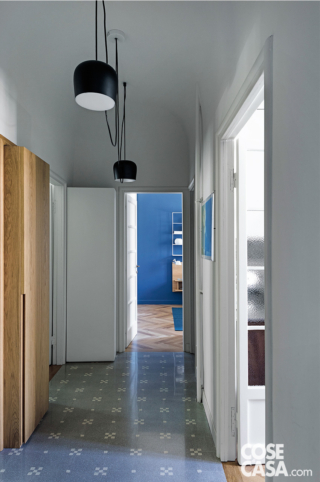 Corridoio di ingresso con pavimento in cementine e armadiature in rovere che integrano e nascondono le partizioni murarie Corridoio di ingresso con pavimento in cementine e armadiature in rovere che integrano e nascondono le partizioni murarie