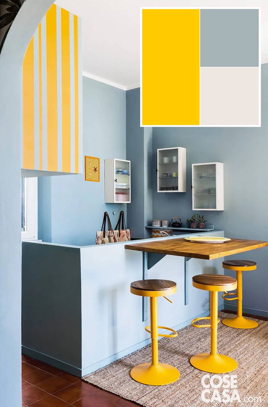 Diverso è l'uso del giallo in questa piccola cucina luminosa: accanto a un piano di legno massello che funge da tavolo sono stati posizionati degli sgabelli con seduta in legno, che sono realizzati in metallo di colore giallo.
Essi danno allegria e solarità all'ambiente, e questo effetto è accentuato dal grande pensile a righe verticali che alterna il giallo all'azzurro, colore quest'ultimo richiamato anche nelle pareti che formano l'angolo, contribuendo a creare un insieme brioso e leggero. Foto: Alessandra Ianniello. Styling: Marilù Benini. Progetto d’interior: Officina Interior, Ig: @officina.interior.