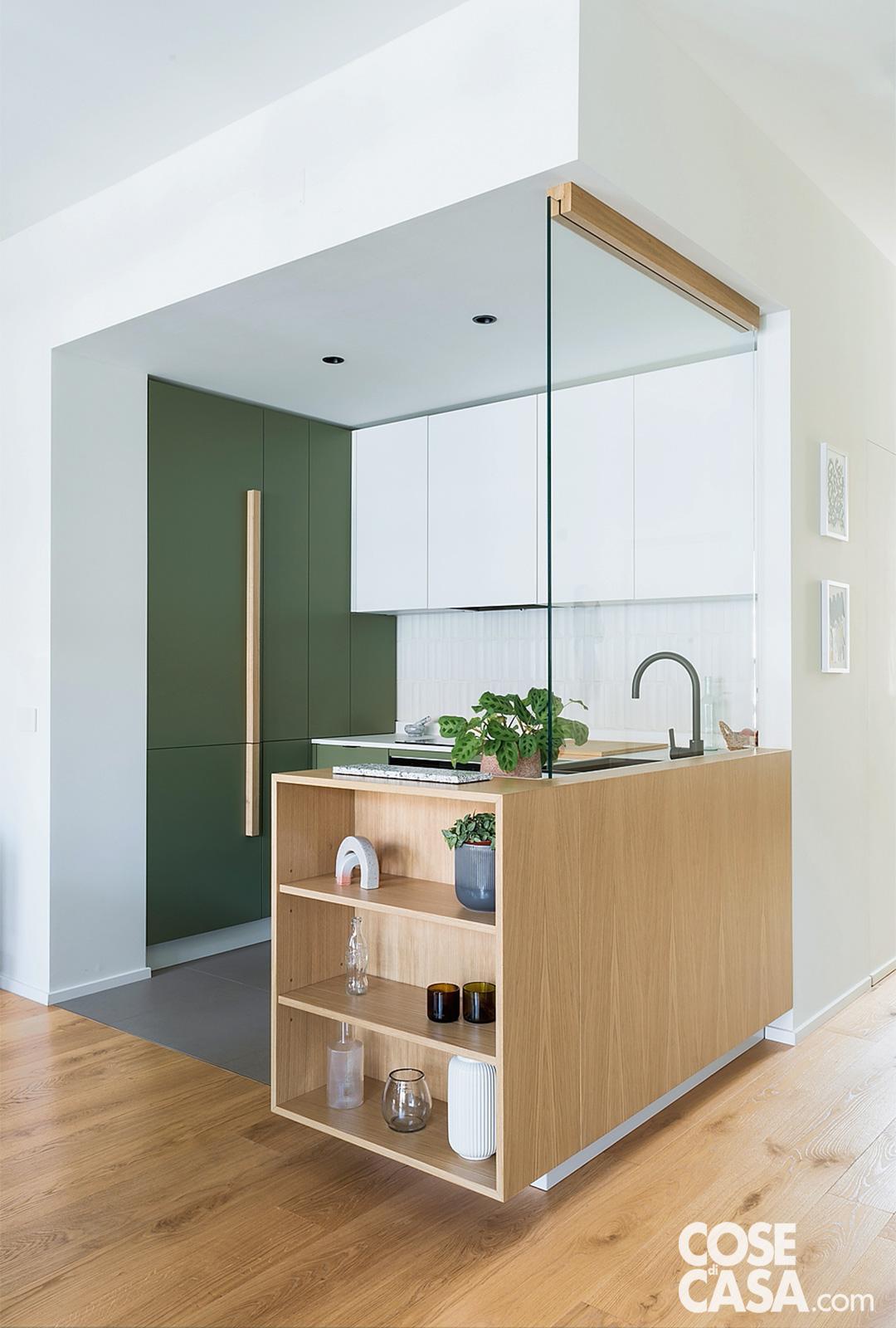 Questa cucina angolare di piccole dimensioni sfrutta lo spazio con intelligenza e leggerezza visiva. La composizione si sviluppa su due angoli distinti: il primo si apre in una penisola, elemento funzionale e conviviale, sormontata da un vetro che separa senza chiudere, lasciando filtrare la luce. Il secondo lato è più operativo, con armadiature a tutta altezza che incorniciano la zona centrale composta da basi e pensili, ottimizzando contenimento e continuità visiva. La palette bianco e verde contribuisce a rendere l’insieme luminoso e fresco, perfetto per amplificare la percezione dello spazio in un ambiente compatto. Progetto: R3 Architetti.
Foto: Marco Popescu.