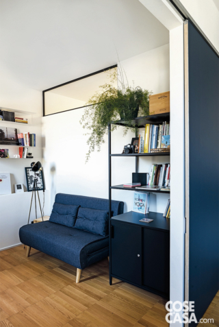Anche nello studio, usato spesso come camera per gli ospiti, una finestra interna è stata ritagliata in alto nella parete divisoria. In questo modo l'attiguo ambiente di servizio, altrimenti cieco, gode di luce naturale. La stanza è separata dal soggiorno tramite una delle due ante mobili blu. Anche nello studio, usato spesso come camera per gli ospiti, una finestra interna è stata ritagliata in alto nella parete divisoria. In questo modo l'attiguo ambiente di servizio, altrimenti cieco, gode di luce naturale. La stanza è separata dal soggiorno tramite una delle due ante mobili blu.