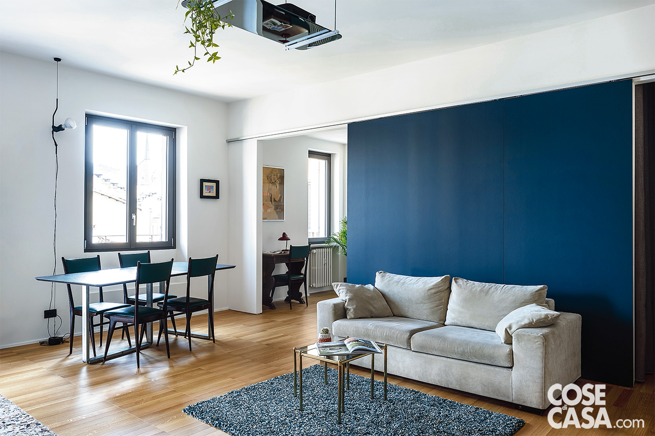 Quando entrambe le ante scorrevoli sono aperte, risultano affiancate al centro della parete e formano uno sfondo colorato dietro al divano, che è leggermente scostato dal muro. Quando sono chiuse, e ciascuna tampona il proprio vano di passaggio, la composizione cromatica a parete varia e le ante danno vita a un'alternanza fra il bianco (del muro) e il blu di cui sono rivestite, tinta ripresa anche dal tappeto di Ikea (www.ikea.com). Quando entrambe le ante scorrevoli sono aperte, risultano affiancate al centro della parete e formano uno sfondo colorato dietro al divano, che è leggermente scostato dal muro. Quando sono chiuse, e ciascuna tampona il proprio vano di passaggio, la composizione cromatica a parete varia e le ante danno vita a un'alternanza fra il bianco (del muro) e il blu di cui sono rivestite, tinta ripresa anche dal tappeto di Ikea (www.ikea.com).