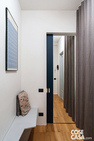 Ingresso con porta a specchio che aggiunge profondità visiva Ingresso con porta a specchio che aggiunge profondità visiva