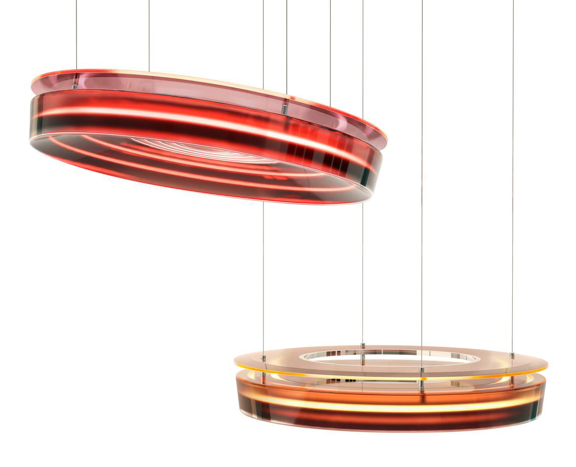 Le lampade a sospensione  Phebe di Draga & Aurel sono realizzate a mano e  sono composte da due dischi con inclinazione regolabile per diffondere la luce con intensità mutevole. Quello superiore, in lucite, è sottile e luminoso, mentre quello inferiore è realizzato con numerose colate di resina epossidica con cromie e sfumature differenti. https://draga-aurel.com – Fuorisalone, Galleria Rossana Orlandi – Via Matteo Bandello 14, Milano.