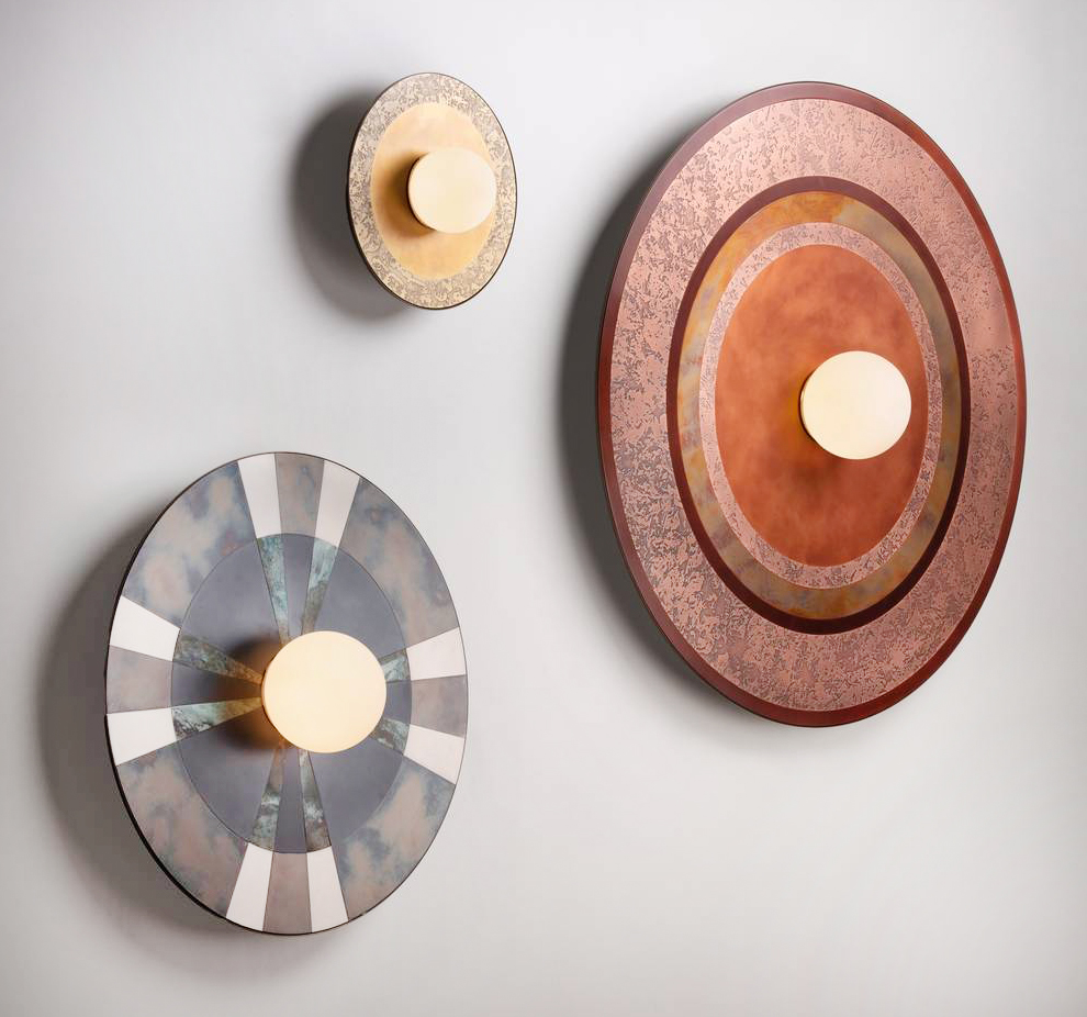 Le lampade da parete della collezione Caleide di De Castelli sono caratterizzate da una sottile lastra circolare, che accoglie il bulbo di vetro opalino soffiato con la fonte luminosa, con un intreccio metallico: acciaio, ottone e rame, con finiture ossidate e spazzolate. Sono disponibili in tre formati e  tre decori. https://decastelli.com - Fuorisalone, De Castelli Gallery – Via Visconti di Modrone 20, Milano.