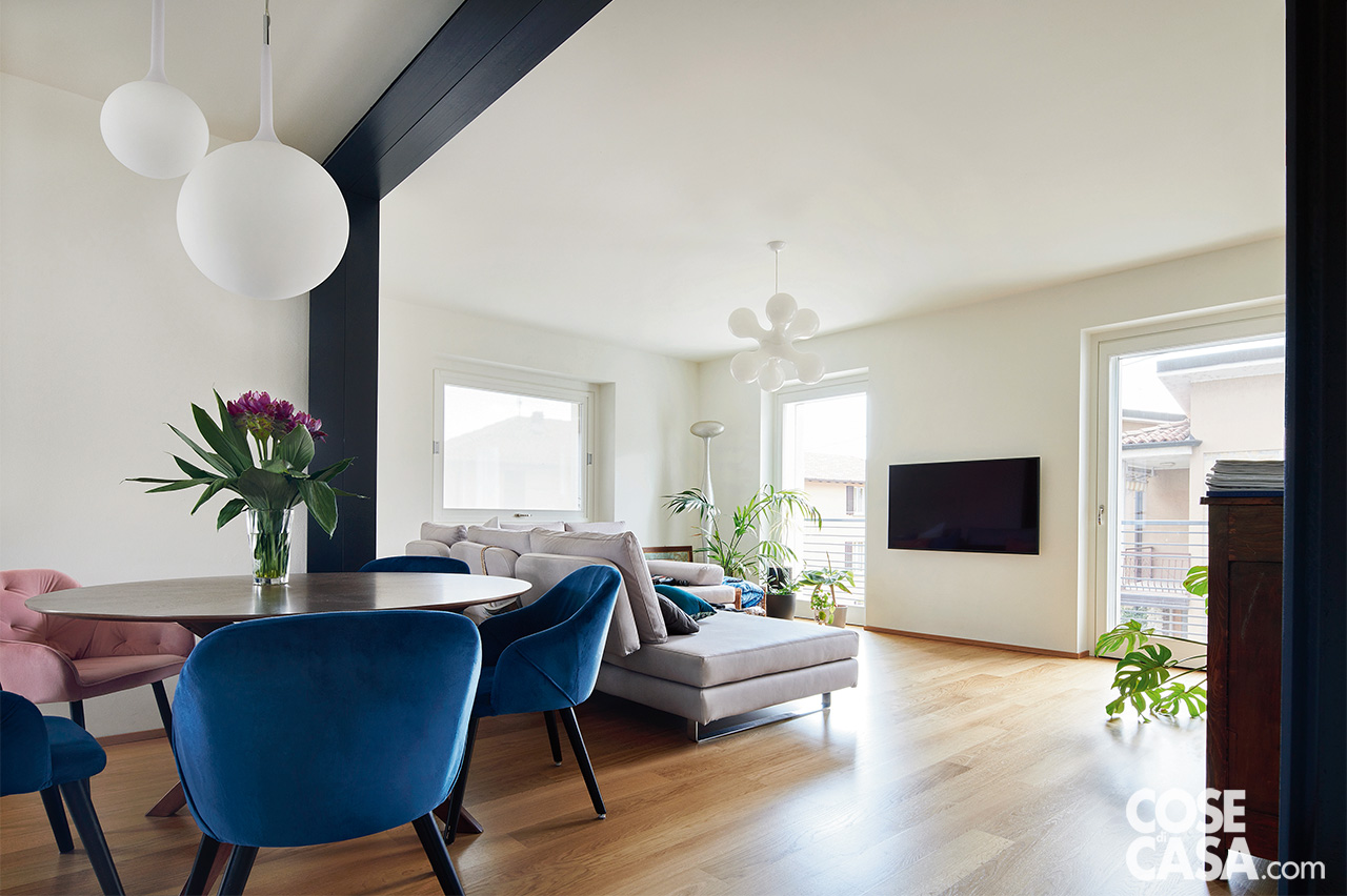 living divano grigio angolare tavolo da pranzo con sedie blu e rosa