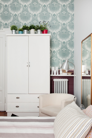 Nella cameretta del bebè l'armadio in legno è stato realizzato su disegno e dipinto di bianco e valorizzato da uno sfondo a parete con carta da parati Farrow & Ball, Lotus - Oval Room Blue/ All White [1574.11], con disegni blu-verde su fondo bianco. Progetto e foto architetto Clara Bona.