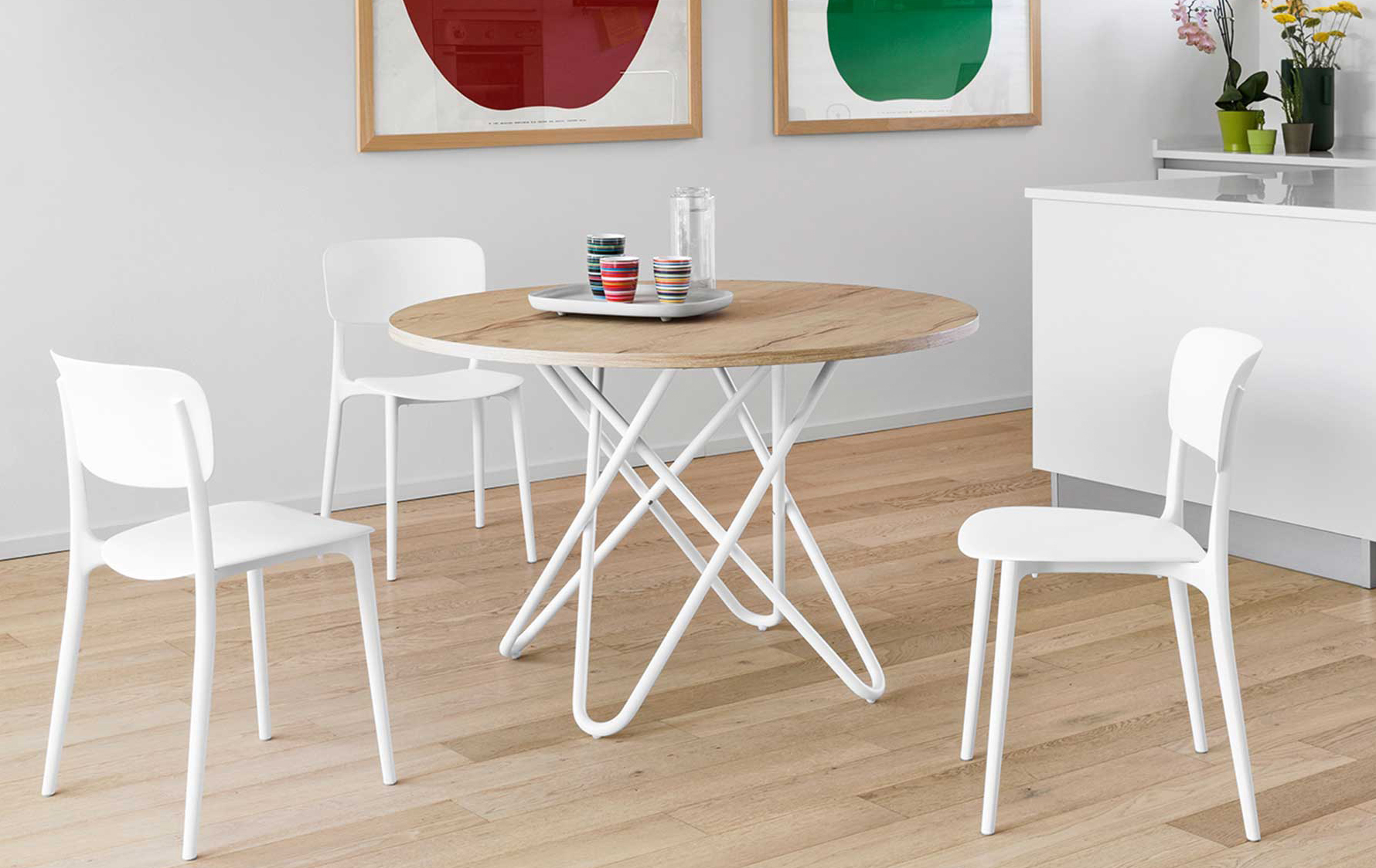 Riprendono il colore bianco candido delle ante della cucina le sedie impilabili Liberty di Calligaris accostate al tavolo con il piano rotondo nella finitura legno chiaro. Sono completamente realizzate in polipropilene bianco opaco, che le rende adatte anche all'esterno, e hanno una  linea che riprende i classici modelli Thonet. Misurano L 46 x P 51 x H 80 cm. Prezzo a partire da 137 euro cad. https://www.calligaris.com