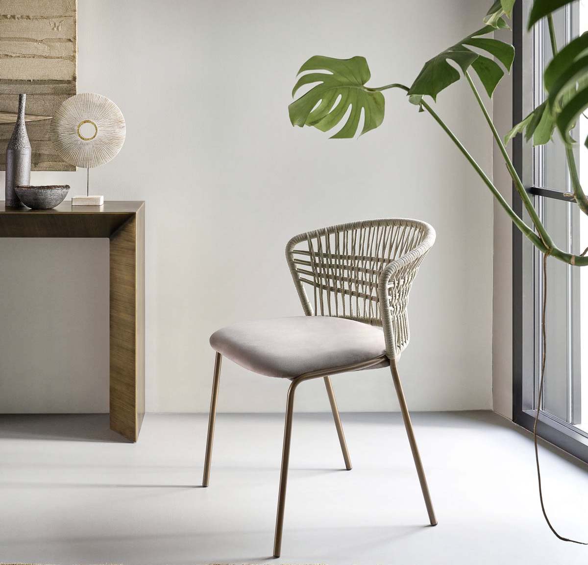 Rappresenta l'incontro tra la sartorialità e il design contemporaneo la nuova seduta Soffio di Riflessi che è caratterizzata dalla base in tubolare metallico nella raffinata e sempre più apprezzata finitura bronzo. Lo schienale con una trama intrecciata, realizzata a mano con cordino nautico ignifugo e idrorepellente color sabbia, si trasforma nell'elemento distintivo. https://www.riflessi.it - Fuorisalone, Store Milano – Piazza Velasca 6, Milano.