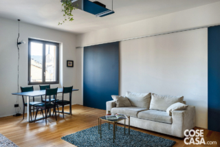 In soggiorno, la parete alle spalle del divano presenta una soluzione funzionale e insieme decorativa. Si tratta di un sistema divisorio scorrevole, composto da un binario e da due ante mobili, che separa il soggiorno dall'ingresso da una parte, e dallo studio/stanza degli ospiti dall'altra. In soggiorno, la parete alle spalle del divano presenta una soluzione funzionale e insieme decorativa. Si tratta di un sistema divisorio scorrevole, composto da un binario e da due ante mobili, che separa il soggiorno dall'ingresso da una parte, e dallo studio/stanza degli ospiti dall'altra.