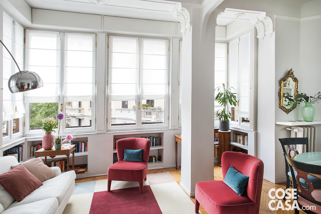 soggiorno con bow window divano bianco e poltroncine